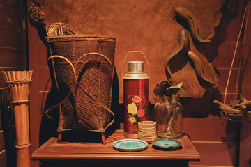 A display of traditional vintage antiques including woven baskets and chinese thermos flasks