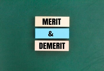 colored paper with the words Merit and Demerit. noun. a quality deserving blame. Merit, demerit and its retributions at the level of the individual.