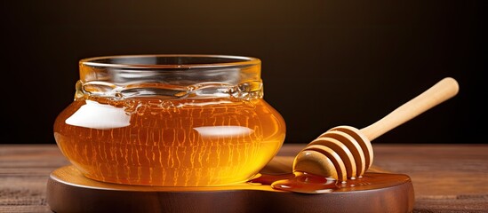 Photo of honey-filled glass bowl with wooden spoon.