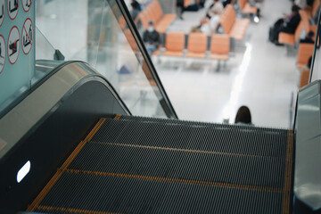 Close up of modern escalator in the airport with waiting seat background. Escalator at an airport...