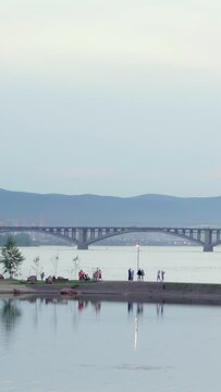 View of the center of Krasnoyarsk and the famous Communal Bridge in evening time, vertical panorama