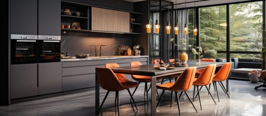 Grey modern kitchen with cabinets, LED lights, black marble details, appliances, and orange chairs at dining table. - obrazy, fototapety, plakaty