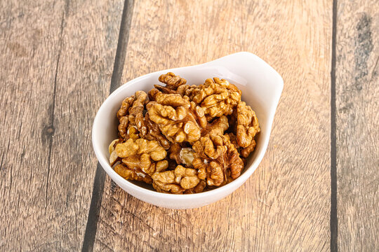 Cracked unshelled walnut in the bowl