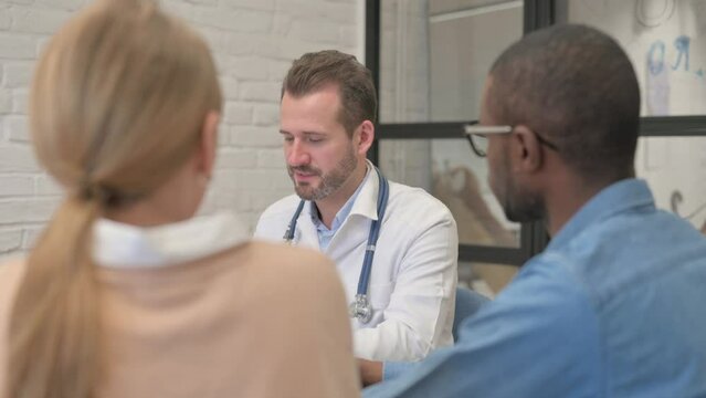 Close up of Male Doctor Talking with Mixed Race Couple