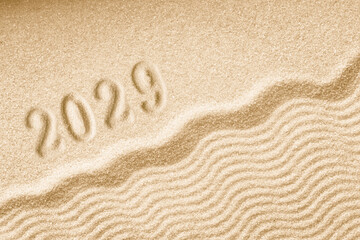 Fototapeta na wymiar Imprints of numbers 2029 happy new year on a golden sand waves