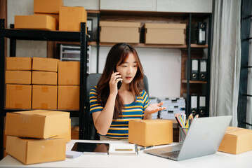 Young woman holding a smartphone, tablet showing payment success and credit card with yellow parcel box as online shopping concept