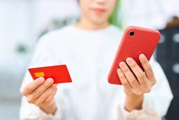 クレジットカードとスマートフォンを持つ女性の手元 - obrazy, fototapety, plakaty