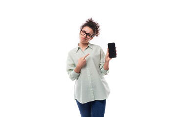 young leader woman with curly black hair in glasses dressed in a shirt holding a smartphone