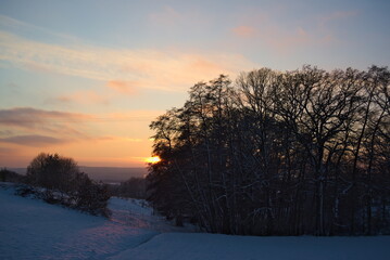 Stimmungsvoller Sonnenuntergang am kalten Winterabend nach dem ersten Schnee