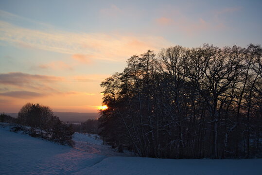 Stimmungsvoller Sonnenuntergang am kalten Winterabend nach dem ersten Schnee