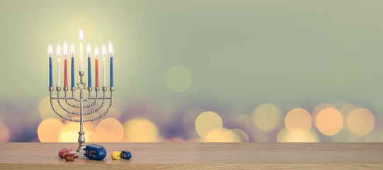 Hanukkah Chanukah Jewish holiday background with menorah (Judaism candelabra candlestick) Hebrew Festival of Lights, Feast of Dedication with burning candle candlelight bokeh and traditional Dreidrel 