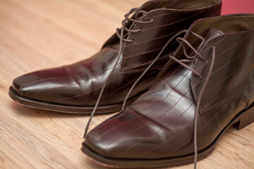 This image captures a pair of classic brown leather dress shoes with a sophisticated sheen. The intricate detailing of the shoes' construction, including the fine stitching and the elegant design of