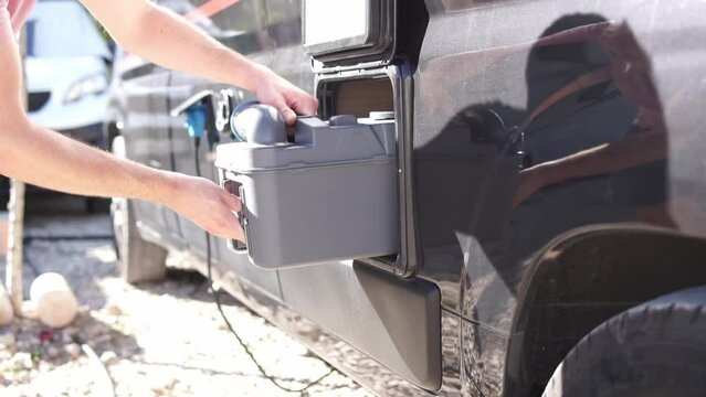 man inserts the chemical toilet tank into place. Motorhome.. RV Life Essentials: Emptying the Chemical Toilet - A Practical Guide for Travelers. High quality FullHD footage