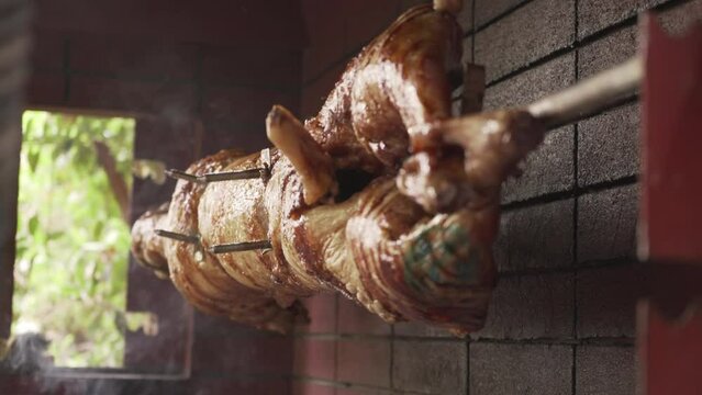 Static side view of lamb spit turning over charcoal for Easter traditional celebration in Greece, focus rack 4K