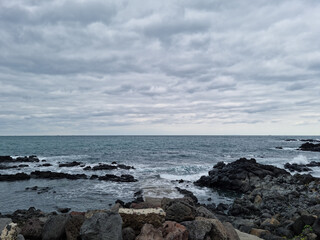The rough sea of ​​Jeju is covered in dark clouds.