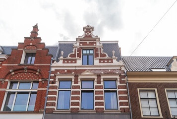 View of facade with decorated gable of Dutch residential building in Haarlem, Netherlands.
