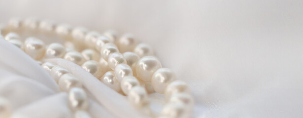 The soft focus on the pearls exudes a gentle, soothing aura on a pristine white fabric. It subtly champions the cause of natural beauty in a world obsessed with manufactured perfection.