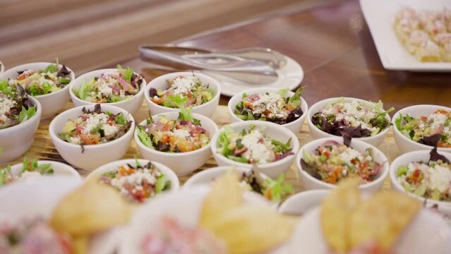 Buffet food presented on individual plates. Salad, crab dip with chips. Corporate, wedding or event buffet meal.