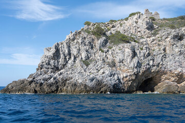 old tower ruin and steep rocky cliffs at Cala Moresca cape, Argentario, Italy