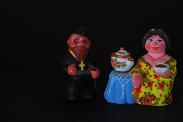 Ceramic figurines. A woman with a kettle, a samovar. Tea party. Close-up.