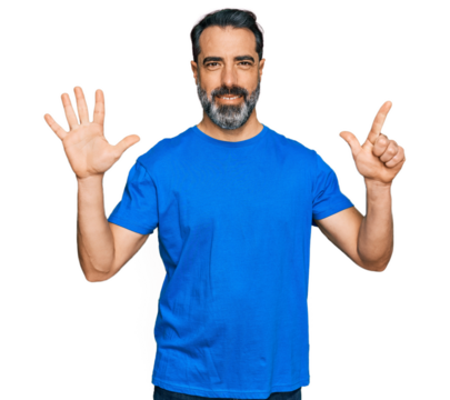 Middle aged man with beard wearing casual blue t shirt showing and pointing up with fingers number seven while smiling confident and happy.