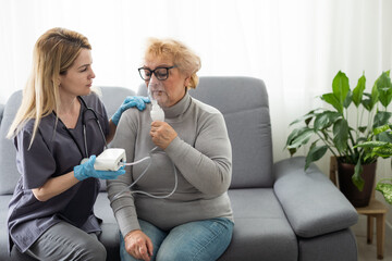 Elderly woman using inhaler for asthma and respiratory diseases at home - obrazy, fototapety, plakaty