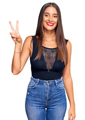 Young hispanic woman wearing casual clothes showing and pointing up with fingers number two while smiling confident and happy.