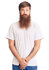 Obraz premium Handsome young red head man with long beard wearing casual white tshirt depressed and worry for distress, crying angry and afraid. sad expression.