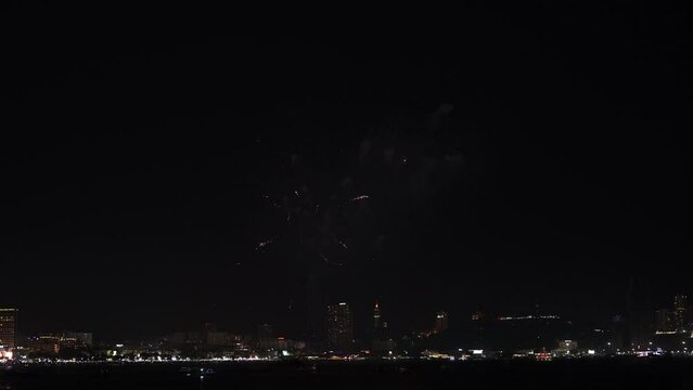 Fireworks shoot from the boat on the sea.