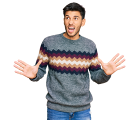 Young handsome man wearing casual winter sweater crazy and mad shouting and yelling with aggressive expression and arms raised. frustration concept.