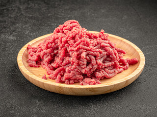 Plate of raw minced beef fillet on grey background