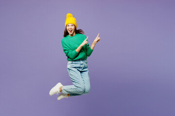 Full body young woman she wear green sweater yellow hat casual clothes jump high point index finger...