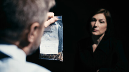 A police detective is questioning a woman in custody about illegal drugs, suspecting her of a crime