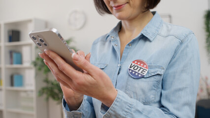 A young woman is using her phone to cast a vote on the elections website, engaging in online voting