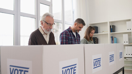 Citizens are voting at the polling place, casting their votes on ballots during elections day