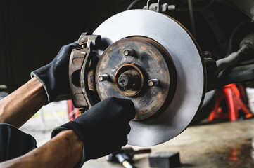Auto mechanic installing car front brake caliper and brake pads.	
 - obrazy, fototapety, plakaty