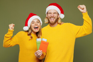Traveler winner couple friends man woman wear sweater Santa hat hold passport ticket isolated on...