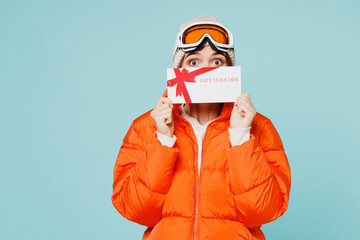 Skier young woman wear windbreaker jacket hat ski goggles mask hold cover mouth store gift coupon...