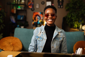 Delighted young afro american dark skinned teen blogger smiling wearing casual outfit and...