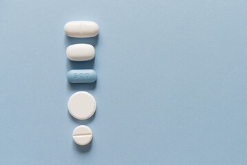 Row of white and blue tablets of different sizes and shapes on a blue background. Mock up for special offers as advertising. Medical and healthcare concept. Empty copy space for text or logo