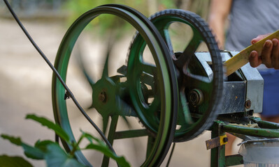 Expert Hands Extracting Sugar Cane Juice Using an Ancient Machine