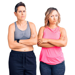 Couple of women wearing sportswear skeptic and nervous, disapproving expression on face with...