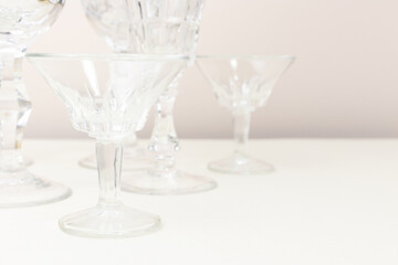 Crystal glasses in front of beige background. Minimal composition.