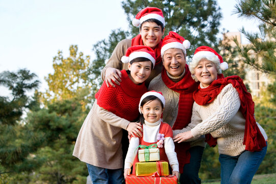 Multi Generation Family Wearing Santa Hats with Christmas Gifts