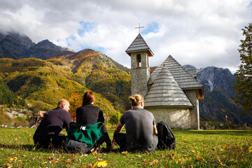 Small Group of Tourists Sitting on a Meadow in Theth, Albania - obrazy, fototapety, plakaty