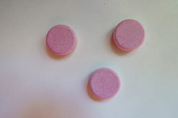 Top view of three big pink oral probiotic tablets