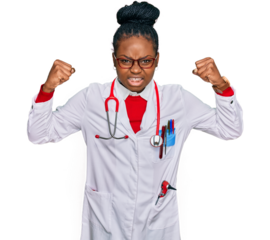 Young african american woman wearing doctor uniform and stethoscope angry and mad raising fists frustrated and furious while shouting with anger. rage and aggressive concept.