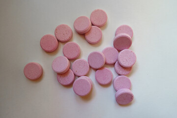 Multiple big pink oral probiotic tablets from above