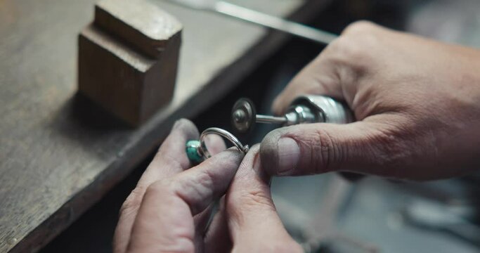 Jeweler in the process of hand-making a blue quartz jewelry ring at jewlery workshop