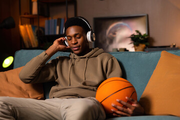Relaxed attractive african american basketball player amatour guy sitting in the living room...